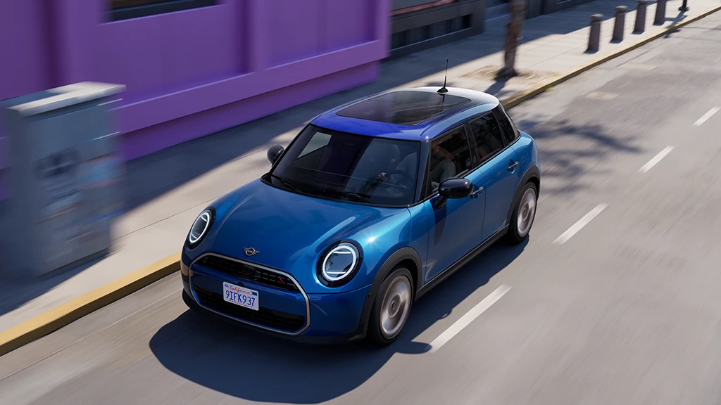 MINI Cooper roulant le long d’une rue urbaine.