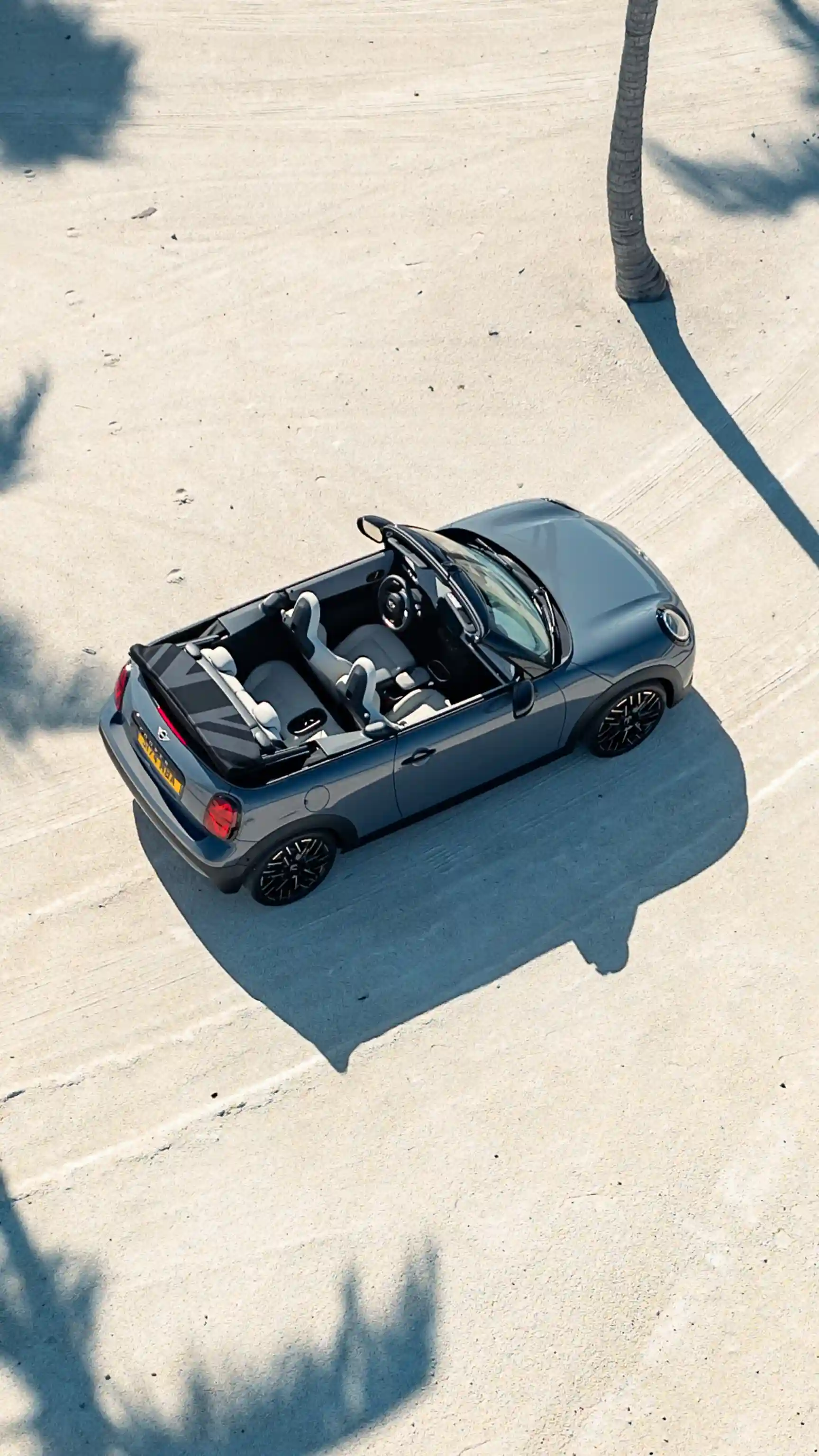 MINI Cooper Cabrio vue de dessus, stationnée sur une surface en béton clair.