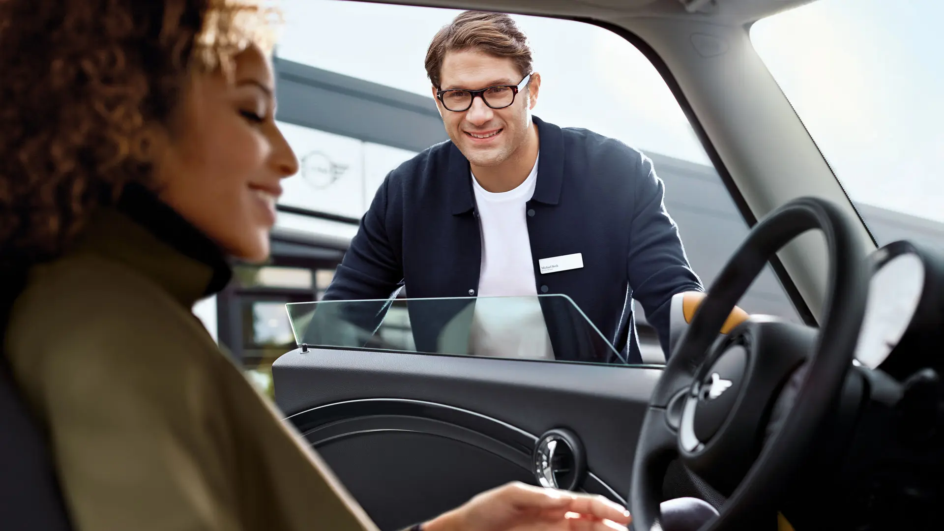 Conseiller service MINI parlant avec un conducteur à l’intérieur d’un véhicule MINI.